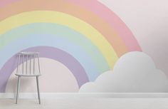 a white chair sitting in front of a rainbow wall mural