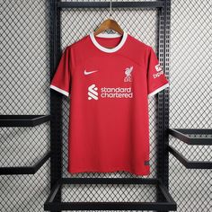 a red liverpool shirt hanging on a rack