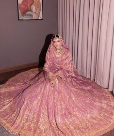 a woman sitting on the floor in a pink dress