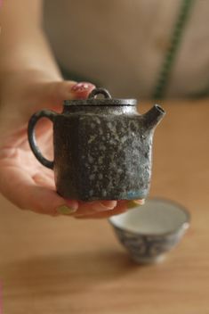 a woman is holding a teapot in her hand