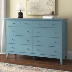 a blue dresser sitting in front of a window