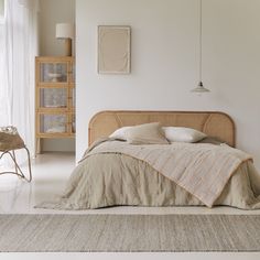 a bed sitting in a bedroom on top of a white floor next to a window