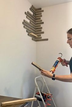 a woman holding a paint roller in front of a ladder