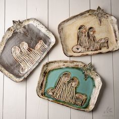 three ceramic trays with nativity images on them