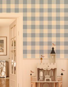 a room with a blue and white checkered wallpaper that has a doll house in it