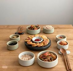 a table topped with bowls and plates filled with food