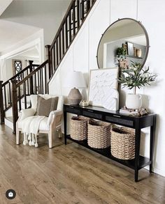 a living room filled with furniture next to a stair case covered in wicker baskets