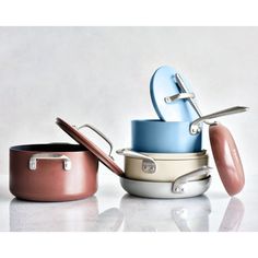 several pots and pans stacked on top of each other with lids in different colors