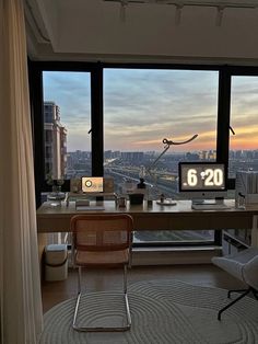 a room with a desk, chair and large window looking out at the city outside