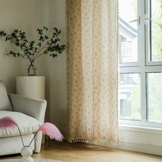 a white couch sitting next to a window in a living room under a pink rug