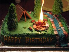 a birthday cake with the words happy birthday on it and a campfire in the middle