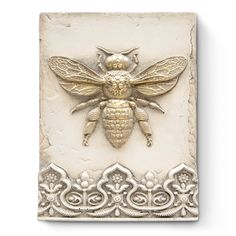 a metal bee on a white background with ornate border around the edges and an intricate design