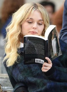 a woman sitting on a bench reading a book