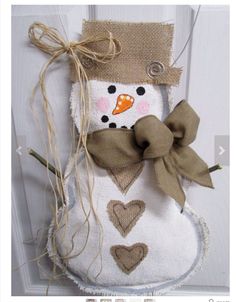 a snowman decoration hanging from the side of a door with a bow on it