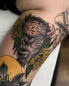 a bison with sunflowers and feathers on his arm is seen in this image