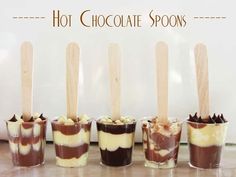 six desserts with wooden spoons lined up on a table