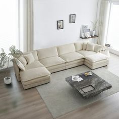 a living room with a large sectional couch and coffee table in the middle, surrounded by windows