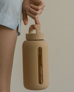 a person holding a water bottle in their right hand and an object in the other