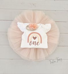 a pink tutu skirt with a one rainbow on the front and a heart at the top