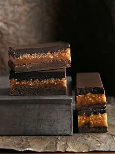 three pieces of chocolate and caramel brownies stacked on top of each other