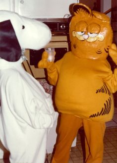 a person in a costume standing next to a dog with a wine glass and looking at each other