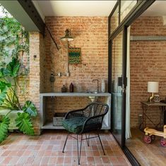 an outdoor living area with brick walls and green plants