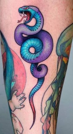 a tattoo with a blue and purple snake on it's leg, next to an octopus