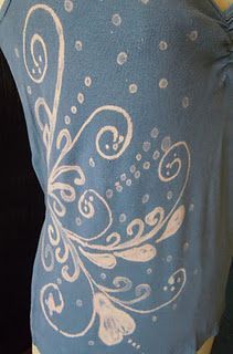 the back of a woman's blue shirt with white swirls on it and polka dots