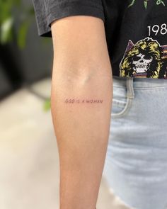 a woman's arm with a tattoo on it that says god is a woman