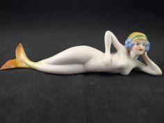 a figurine is laying on the ground with her head turned to the side