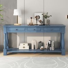 a blue console table with books and pictures on it