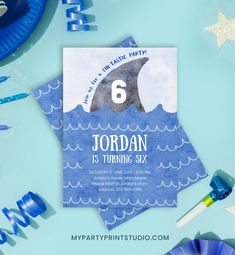 a blue birthday card with a dolphin in the water and stars around it on a table