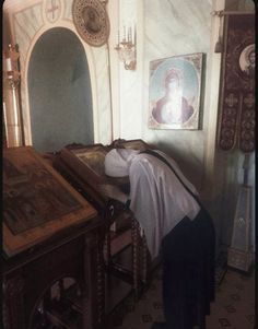 an old photo of a person laying on the ground in front of a wooden table