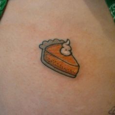 a small piece of cake tattoo on the back of a woman's stomach