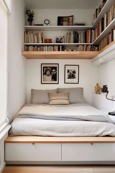 a bed sitting under a book shelf filled with books