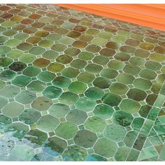 an orange bench sitting on top of a tiled floor