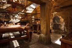 an old wooden table and bench in a room with stone walls, wood beams and exposed ceiling