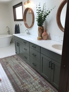 a bathroom with two sinks and a rug in front of it