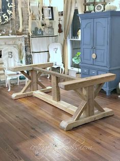 a wooden table sitting on top of a hard wood floor next to a blue cabinet