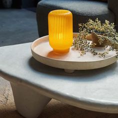 a yellow vase sitting on top of a white table