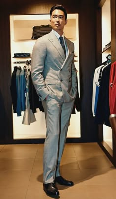 a man in a suit standing next to a closet