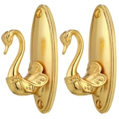 two gold swan shaped hooks on a white background