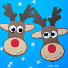 two paper reindeers with googly eyes and snowflakes on blue background, cut out from construction paper