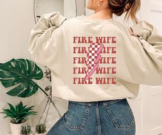 Firefighter Wife Sweatshirt, Fireman Wife Shirt, Fire Wife Shirt, Smoke Jumper, Christmas Firefighter Wife Gift, Fire Chief Wife Gifts WELCOME TO THE COSY STREET FASHION 🚩If you're in search of soft, comfortable, high-quality clothes, you've come to the right place!  We sell trendy and customized sweatshirts, shirts and hoodies also cool gifts for your loved ones. If you have any questions, concerns, or comments about our products, feel free to send us a message anytime 🚩If you want to change or add anything to the design shown in the display picture, please contact the seller through the message box to confirm if the changes can be made 🗨️ SIZE & COLOR -Please check size and color chart before order -Our apparels are unisex 🗨️ OUR PRODUCT -Printed in USA -Products will be made DTF Pri Customized Sweatshirts, Wife Sweatshirt, Fire Wife, Firefighter Wife, Wife Gifts, Fire Chief, Usa Products, Display Picture, Custom Sweatshirts