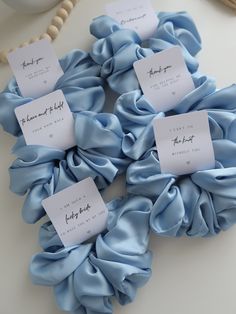 blue scrunffles with white tags on them sitting on a table next to beads