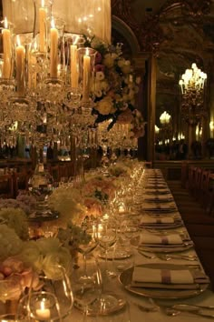 a long table is set with candles and flowers for an elegant dinner or reception in a fancy setting