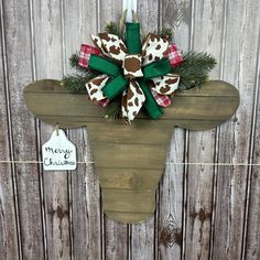 a christmas decoration hanging on the side of a wooden fence with a cow's head