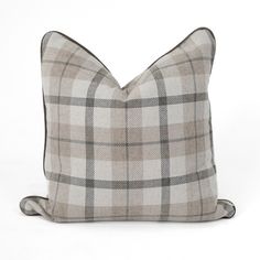 a gray and white plaid pillow on a white background with black piping around the edges