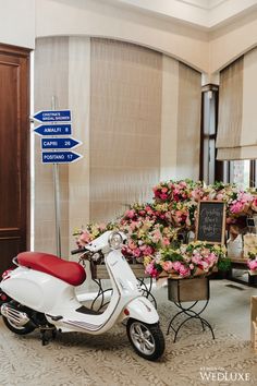 a scooter is parked in front of a bunch of flowers with signs on it