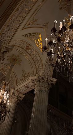 an ornate chandelier hangs from the ceiling in a large room with high ceilings